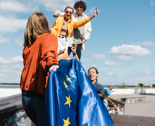 Junge Leute halten eine EU Flagge.